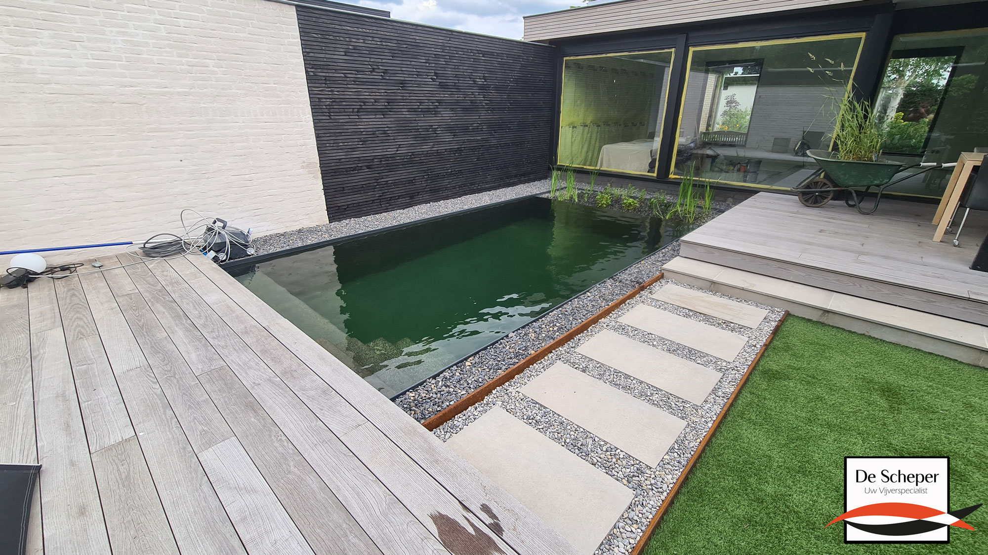 Plaatsing Prefab Zwemvijver Installatie van strakke prefab zwemvijver in moderne tuin, snel en efficiënt aangelegd door Top Zwemvijver.